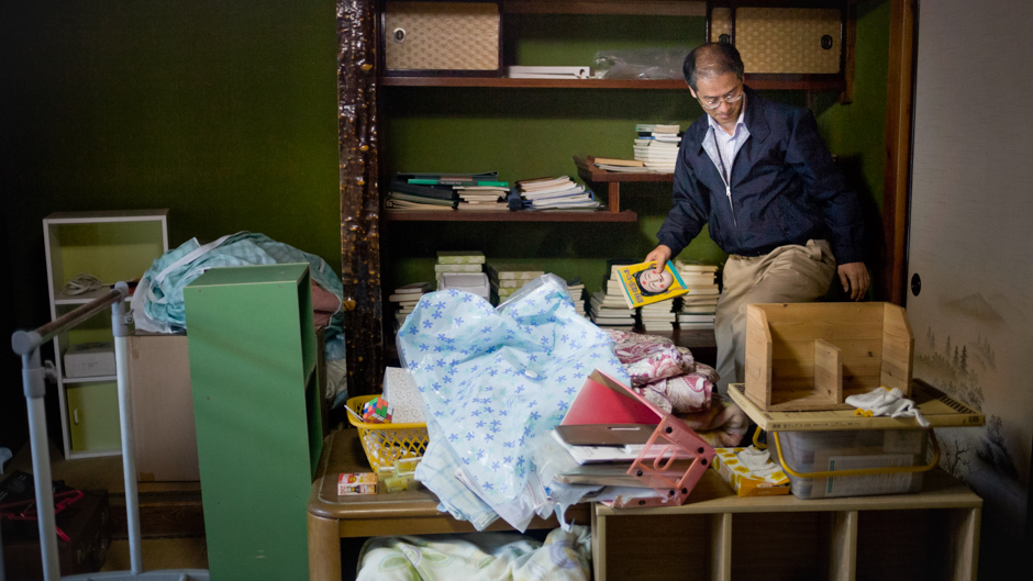 Mr Masakazu Shinkai visiting their abandoned home in Katsurao village in Fukushima prefecture. They had to leave many belonings behind, including most of Mr. Shinkai's books.