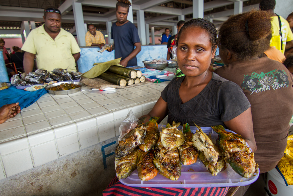 A woman holds cooked reef fish for sale at her stall in Auki market, Malaita Province, Solomon Islands, Photo: Filip Milovac / WorldFish, Creative Commons BY-NC-ND 2.0